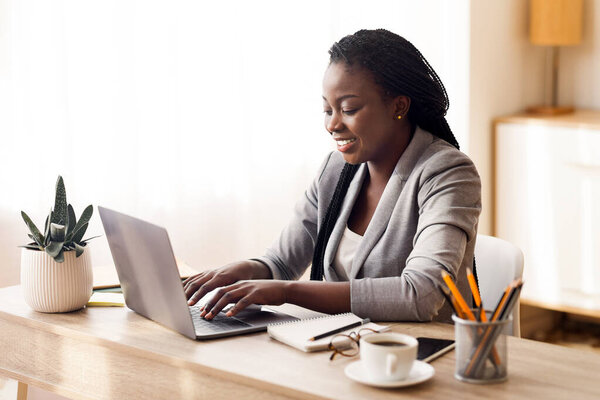 Office work. Black female employee using laptop at workplace, copy space