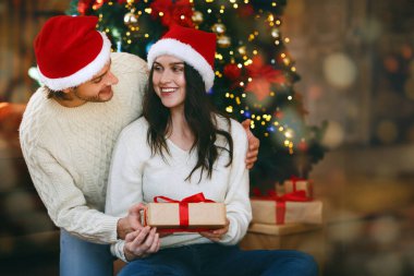 Sevgi dolu koca, güzel karısına Noel hediyesi veriyor, Noel 'i evde kutluyor, boşlukta.