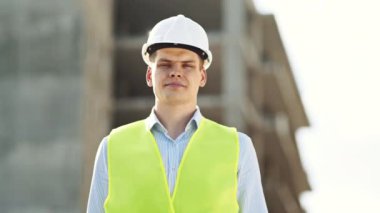 İnşaat işçisi, bir inşaat sahasında kendine güveni tam bir şekilde duruyor ve işyeri güvenliği ve profesyonelliğine bağlılığını gösteriyor..