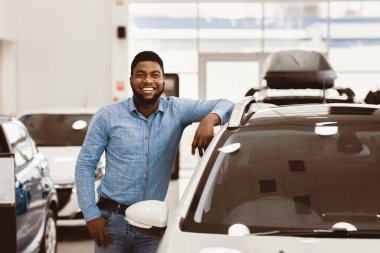 Araba Alıcısı. Satıcıda Yeni Otomobil Dükkanı 'nın yakınında Afro Adam Poz Veriyor' un kutlu olsun. Boşluğu Kopyala