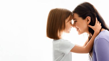 Tatlı güzel kızının genç annesine sarılıp yattığı beyaz arka plan, boş alan.