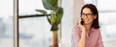 İş görüşmesi. Cep telefonuyla konuşan mutlu bir kadın, danışmanlık yapan bir müşteri, dizüstü bilgisayar kullanan ve kopyalama alanını bir kenara bırakan...