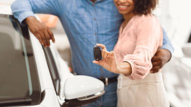 Otomobil almak. Tanımlanamayan bir çift yeni araba anahtarlarını gösteriyor. Satıcıda duruyorlar. Panorama, Kırpılmış, Sığ Derinlik