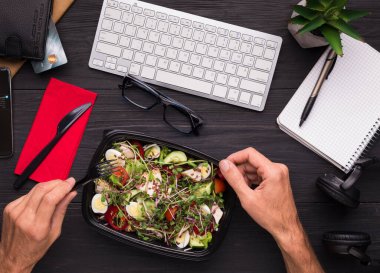 İşyerinde öğle yemeği. Çalışma masası, üstten görünüm, sağlıklı salata zevk iş adamı