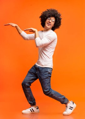 Turuncu stüdyo arka planda Mısır tarzında dans, komik siyah adam kandırmak