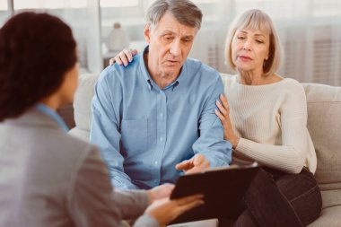 Son arzum ve vasiyetim. Kıdemli adam, karısıyla kanepede oturuyor, belgeleri kontrol ediyor, danışmanla evrakları imzalıyor.