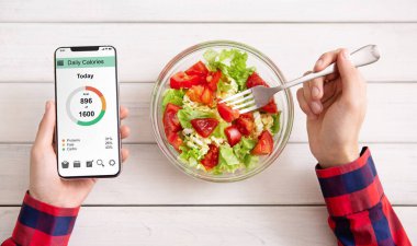 Beslenme ve diyet kavramı planlama akıllı. Yeme sebze salatası adam ve mobil uygulama kalori sayma, sayfa görünümü