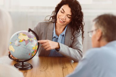 Trip 'i seçiyorum. Güzel Meksikalı ajan olgun çiftlere son dakika seyahat teklifi sunuyor. Dünya 'yı, kopyalama alanını işaret ediyor.