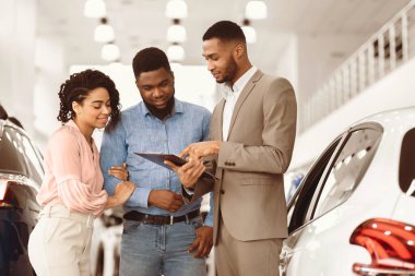 Araba satışı. Afro Eşler, Lüks Satış Mağazasında Duran Satıcıyla Oto Danışmanlık Alıyor.