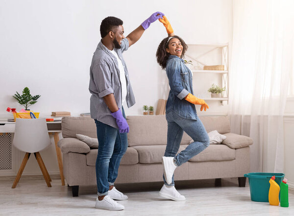 Loving African American Couple Dancing While Cleaning Flat Together, Having Fun At Home, Copy Space