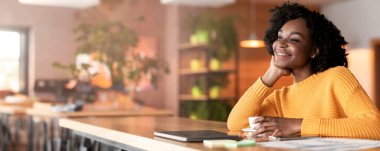 Kafede çay içip zengin bir gelecek hayal eden heyecanlı afro kız.