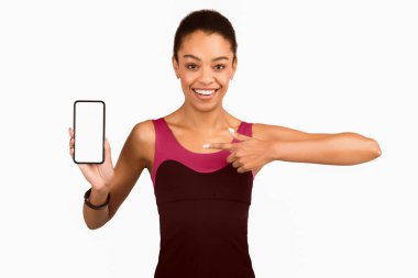 Harika Fitness Uygulaması. Beyaz Stüdyo Arkaplanının Üzerinde Parmak Gösteren Akıllı Telefon Boş Ekran Gösteren Mutlu Afro Kadın. Model