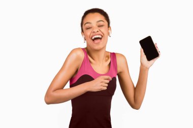 Kulaklıklı Siyah Kadın, Beyaz Arkaplanda Dans Eden Boş Ekranlı Akıllı Telefonla Müzik Dinliyor. Stüdyo Çekimi