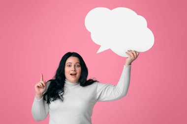 Bir fikrim var. Boş konuşma balonu tutan heyecanlı şişman kadın ve pembe arka plan, boş alan üzerine parmak işareti