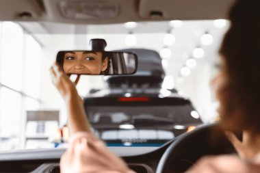 Yeni Araba Konsepti. Sürücü koltuğunda oturan aynaları kontrol eden Afro Kız galeride Oto Alma Testi yapıyor. Seçici Odaklanma