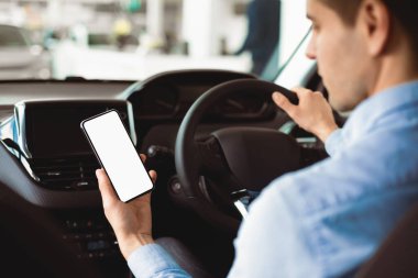 Akıllı Sürüş Uygulaması. Yeni Araba Alma Merkezi 'nde oturan akıllı telefonu kullanan bir adam. Seçici Odaklanma, Uygula