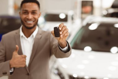 Araba satışı. Tanımlanamayan Yönetici Dükkanda Baş Parmak Gösteren Otomobil Dükkanı 'nın yanında duran Anahtar Jesti. Sığ Derinlik, Uzayı Kopyala