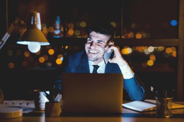 İş görüşmesi. Neşeli İşadamı 'nın cep telefonuyla konuşması Modern Ofiste bir gecede işyerinde oturması.