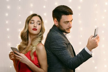 Güvensizlik kavramı. Meraklı kadın, restorandaki tartışmalarından sonra mesajlarını okumaya çalışan akıllı telefonlu sevgililerini dikizliyordu.