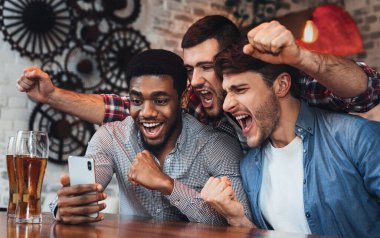 Smartphone cep telefonu ile futbol izlerken ve bira içme erkekler çubuk