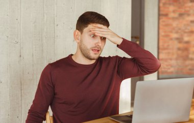 Çok çalışan çalışan, laptopta şoka girmiş, alnına dokunarak ofiste oturuyor. Seçici Odaklanma