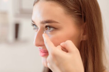 Görüş Konsepti için lenslerle bağlantı kurun. Göz merceği takan gülümseyen kadının yan görünüm portresini kapat