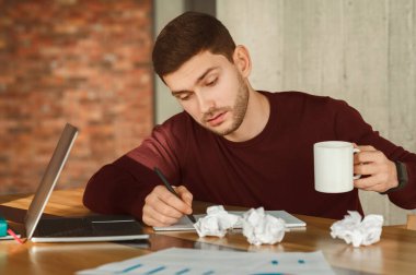 Yorucu bir iş. Çok çalışan çalışanın elinde kahve fincanı var. Neredeyse iş yerinde uyuyor. Seçici Odaklanma