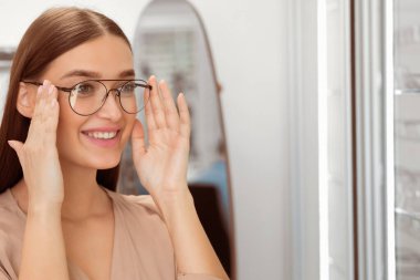 Gözlük Kavramı Seçimi. Optik dükkanında yeni özellikler seçen güzel bir kadının portresi, kopyalama alanı