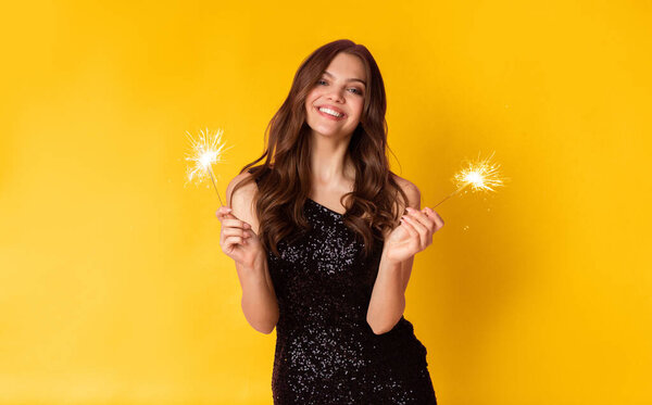 Spark This Party. Cheerful Beautiful Lady Posing With Sparklers In Hands Over Colorful Background And Sincerely Smiling, Copy Space