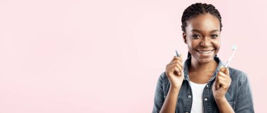 Diş hijyeni. Diş fırçası tutan, diş fırçası tutan, Pembe Stüdyo Arkaplanındaki Diş Temizleme Poz Veren Siyah Kadın