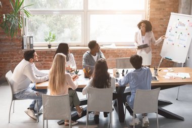 Siyahi bayan çalışanlar sabah brifinginde sunum yapıyor.