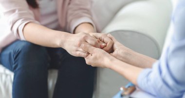 İlgi, güven, profesyonellik kavramı. Terapistin kadın hasta ellerini tutması, müşterisini teselli etmesi, kopya alanla panorama.