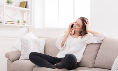 Mutlu kadın evde, rahat kanepede oturan cep telefonunda kopya alanı söz