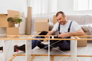 Mavi Kapaklı Mutlu Mobilya Kurucu Rafı tornavidayla tamir ederek İçerde çalışan Kurulum ve Ulaşım Hizmetleri sağlıyor