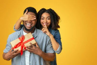 Gizli hediye. Afro-Amerikan kadınlarını seven erkek arkadaşının gözlerini kapayan ve ona hediye veren, yıldönümü ya da doğum günüyle selamlayan