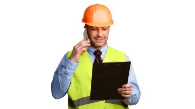 Hardhat 'ta Erkek İnşaatçı Cep Telefonu Konuşuyor Bina Binası Dosya Tutma Projesi Beyaz Arkaplan' ın başında duruyor. İnşaat ustası telefonda konuşuyor. Panorama, Stüdyo Çekimi