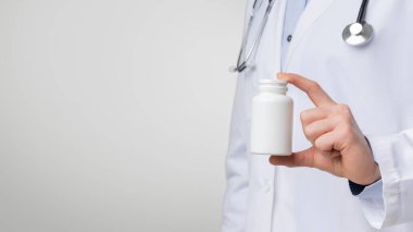 Bilinmeyen erkek doktor elinde boş bir kutu tutuyor. Elinde haplar var. Arka planda, fotokopi alanı olan yakın plan görüntüsü.