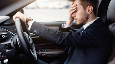 Yorgunluk kavramı. Umutsuzca araba süren, başı ağrıyan, stresli bir menajer.