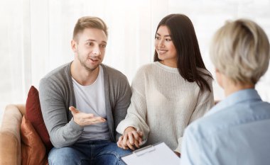 Evlilik danışmanlığı. Ofiste Mutlu Uzlaşmalar İçin Aile Psikologu ile Konuşan Eşler.