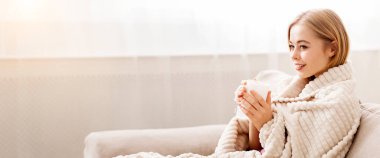 Isınıyorum. Battaniyeye sarılı, sıcak çay içen, evdeki koltukta oturan, yan gören, boş alan olan genç bir kadın.