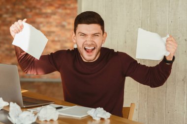 Emotional Office Worker Screaming Crumpling Paper Working At Workplace Indoor. Stressful Job. Selective Focus