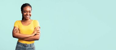 Kendine güvenen siyahi kadın kameraya bakıp gülümsüyor. Mavi Stüdyo 'da el pozu veriyor. Boş Alan