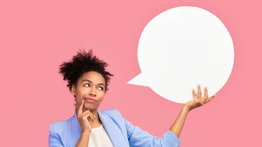 Sanırım öyle. Düşünceli afro kadın boş konuşma balonuna bakıyor, çenesine dokunuyor, telif alanı, pembe stüdyo duvarı.