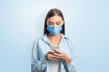 Coronavirus. Koruyucu Maskeli Kadın Zeka Telefonu Kullanıyor Beyaz Arkaplanda Duruyor. Stüdyo Çekimi