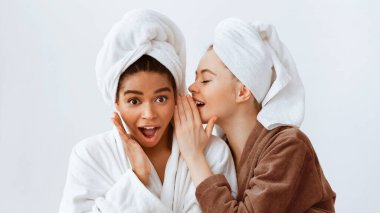 Bu gerçek olamaz. Bornoza sarılmış iki etnik kız arkadaş evde spa yaparken dedikodu yapıyorlar, panorama.