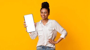 Harika bir uygulama. Milenyum Afro Kadını Boş Siyah Ekranlı Akıllı Telefonu Tutuyor, Sarı Stüdyo Arkaplanının Üzerinde Boş Alan, Model