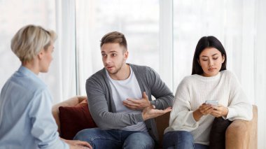 Aile sorunları. Koca, Ofiste Oturan Karı Umursamazlığı Hakkında Evlilik Terapisti Şikayet Ediyor. Seçici Odaklanma