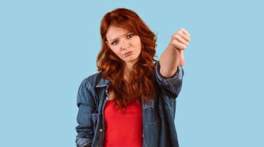 Hoşlanmamak. Memnuniyetsiz Milenyum Kızı, Sarı Stüdyo Arkaplanının Üzerinde Duran Bir Şey Onaylamıyor. Panorama