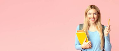 Cevabı biliyorum. Elinde not defteri ve kalemle pembe stüdyo duvarında izole edilmiş güzel, gülümseyen sarışın öğrenci kız.