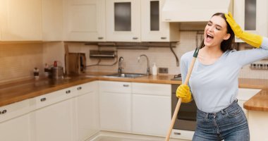 Müzik onu daha iyi bir konsept yapar. Mikrofon olarak paspası kullanan, şarkı söyleyen, modern mutfağı temizleyen tasasız kız.